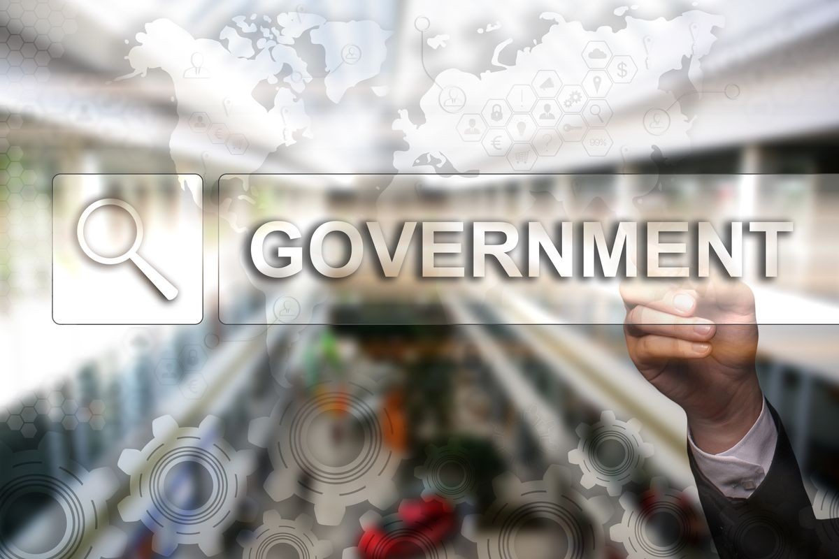 Businessman draws "Government" on the virtual screen. Touch Screen. Virtual Icon. Graphs Interface. Business concept. Internet concept. Digital Interfaces