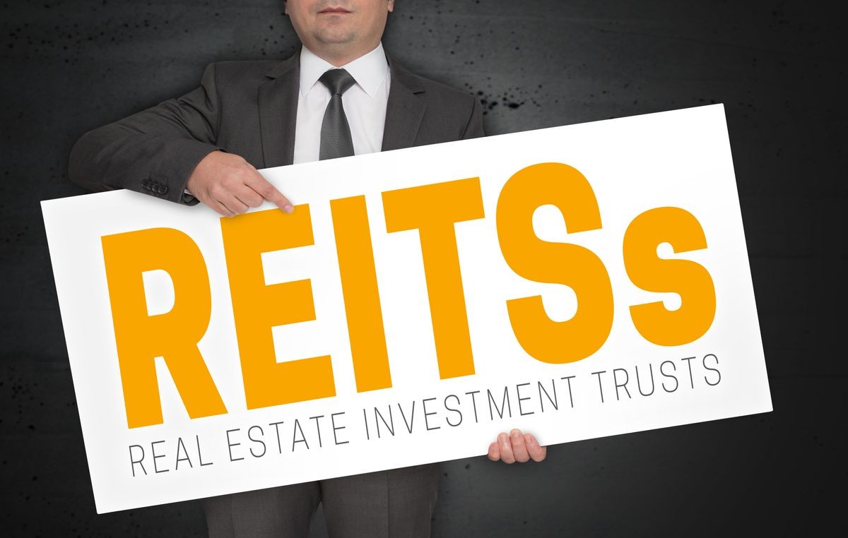 Reit poster is held by businessman.